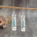 Long geometric silver earrings with turquoise stone accents and retro design