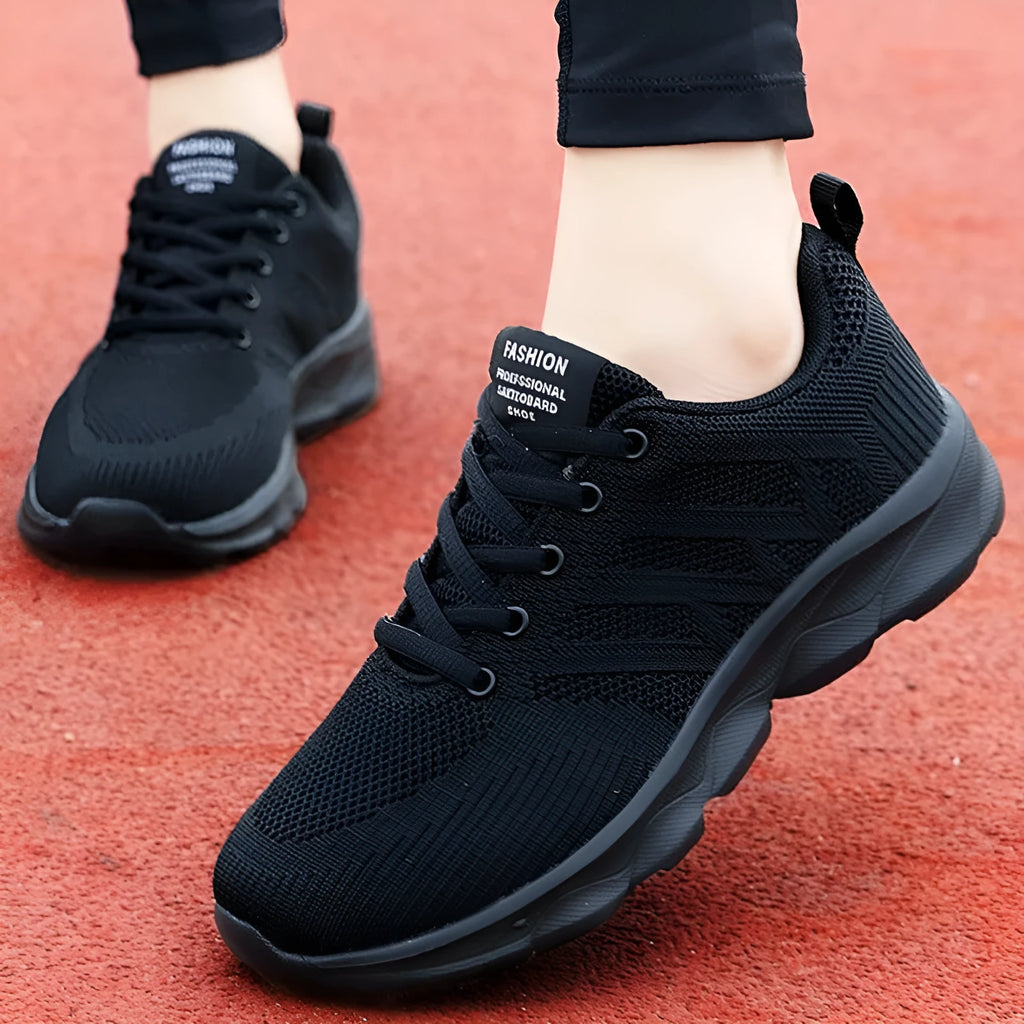 Women's white breathable mesh lace-up shoes with a low heel on a plain background.