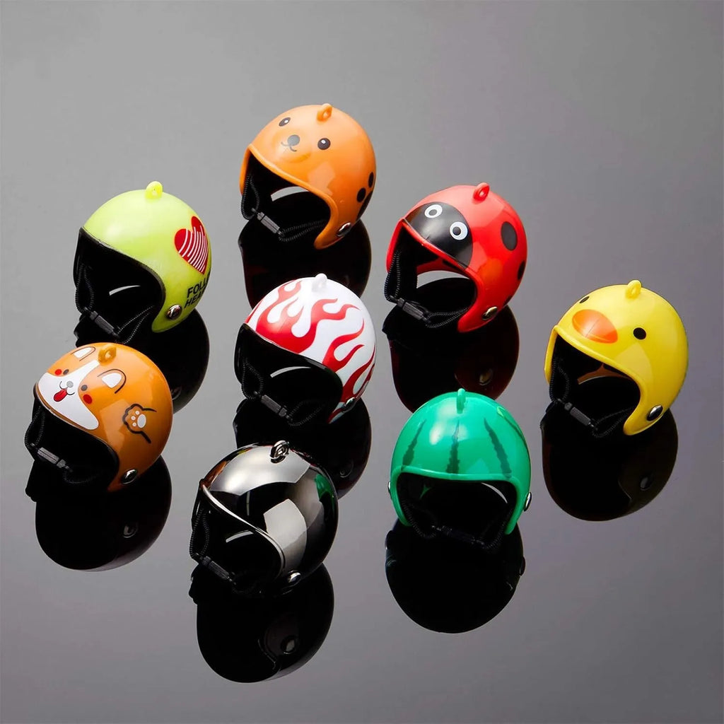 Small hard plastic helmet for a chicken or bird with elastic straps and a colourful design.