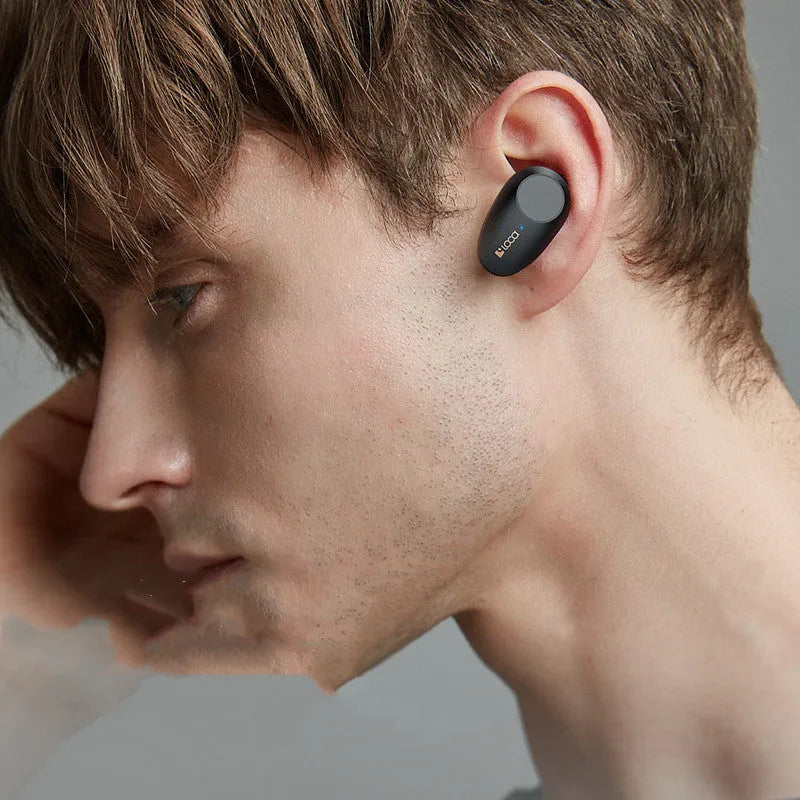 Black wireless Bluetooth headphones with charging stand on a table