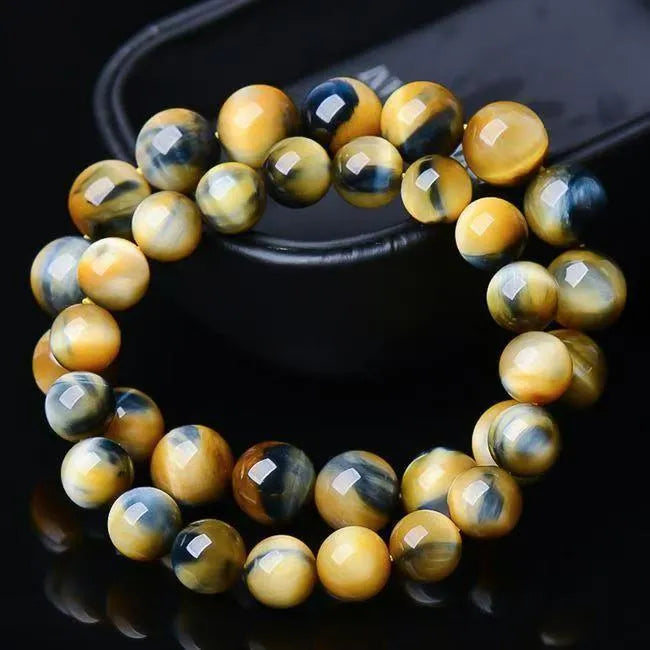 Fantasy Tiger Eye agate bracelet with round beads on a wrist, showing 10mm bead size.