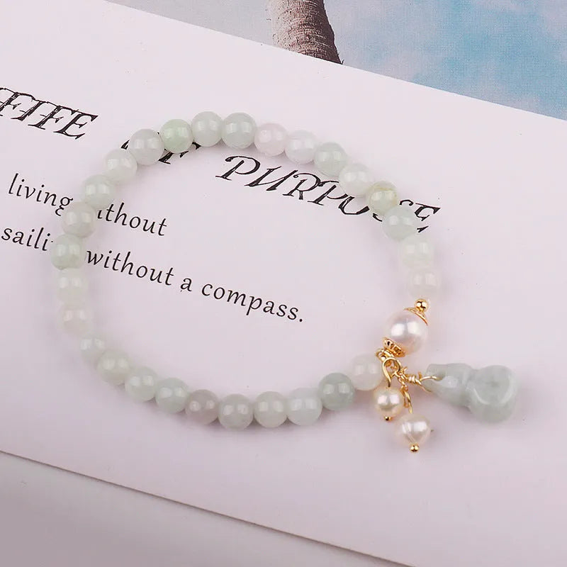 Close-up of a natural emerald jade bracelet with a handcrafted gourd design in Chinese style.