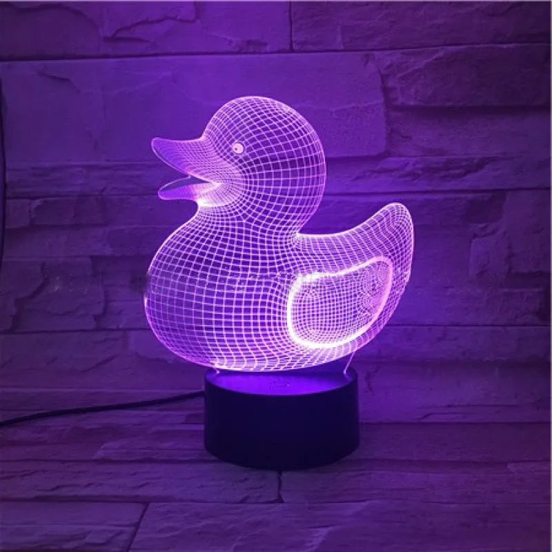 Little yellow duck 3D table night light showing seven colour options on a desk next to its black remote control.