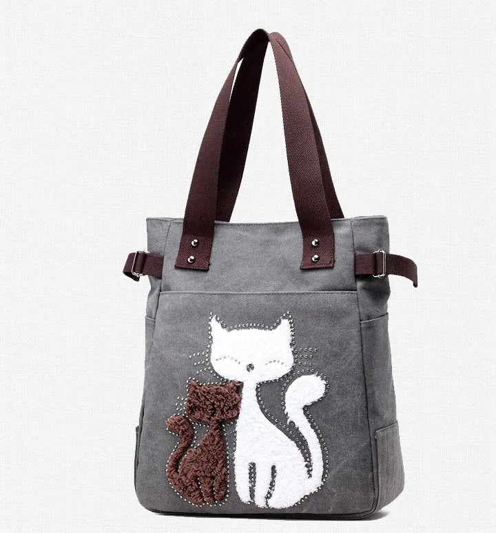 KVKY canvas handbag with plush cat applique in beige colour on a woman's shoulder
