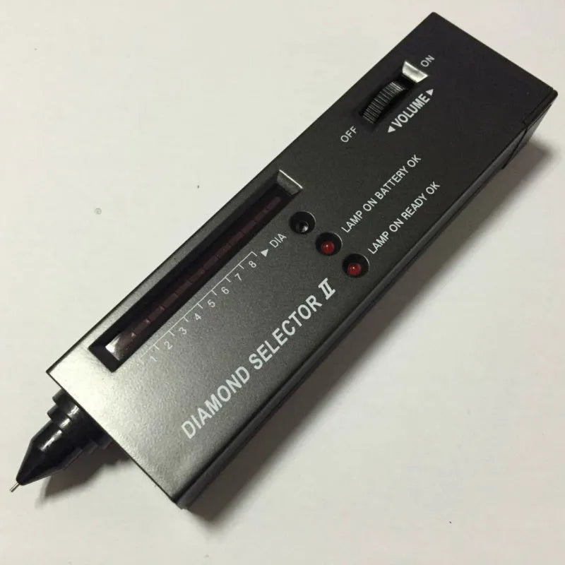 Black second generation diamond thermal conductivity tester with metal probe, shown with scale.