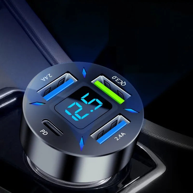 Black four-port USB car charger with digital LED display plugged into a car dashboard socket.