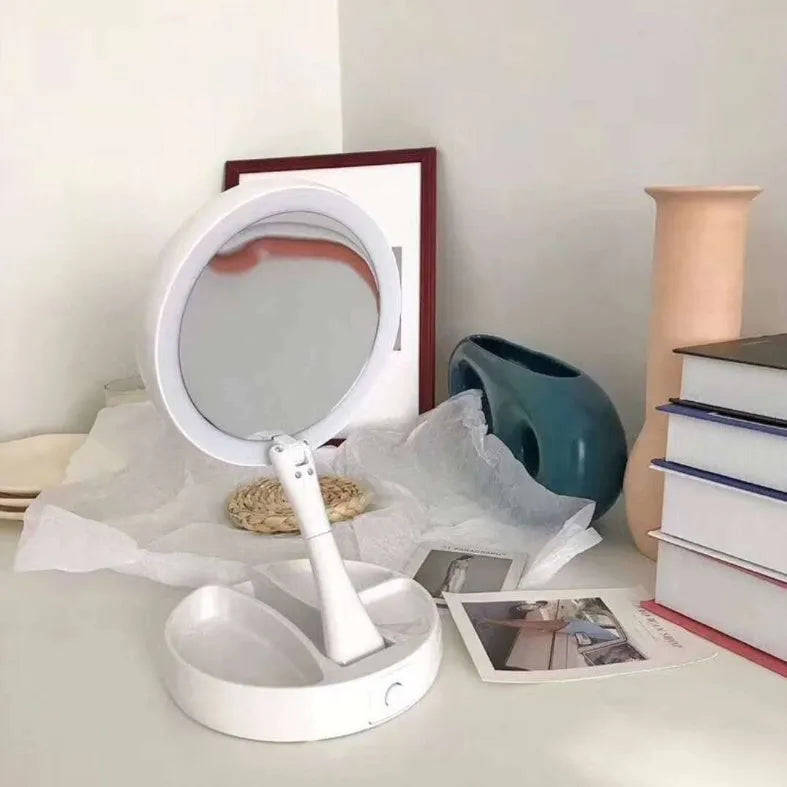 White foldable LED vanity mirror with a ring light, shown open on a table.
