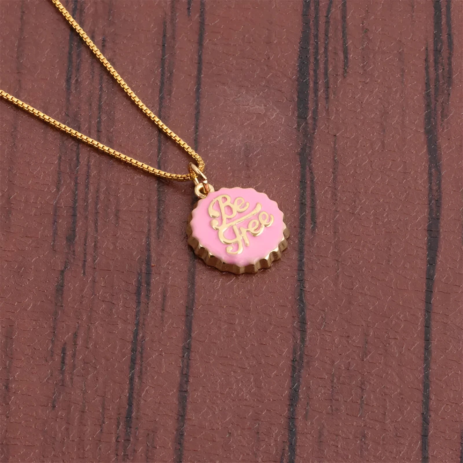 Copper bottle cap pendant necklace on a 40cm box chain with 18K gold electroplating, shown in one of six available colours.