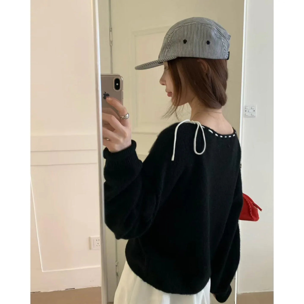 Grey loose-fitting women's knitwear pullover jumper on a hanger.