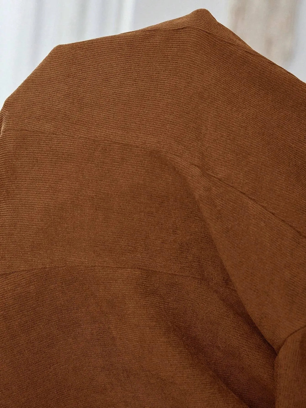 Brown men's single-breasted lapel coat with long sleeves on a hanger