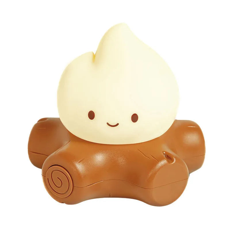 Cartoon silicone small fire pile night lamp with yellow light on a surface.