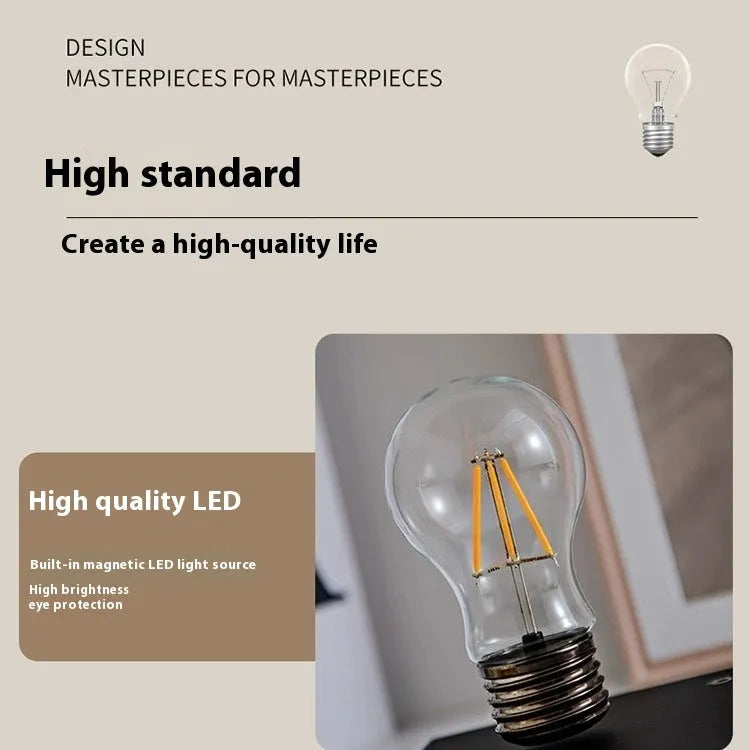 Iron art suspension bulb night lamp on a black wood grain desktop base.
