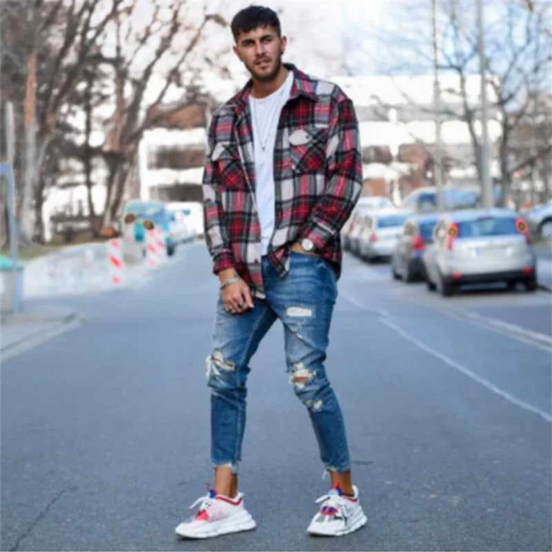 Men's blue jeans with distressed hole detailing on cotton fabric