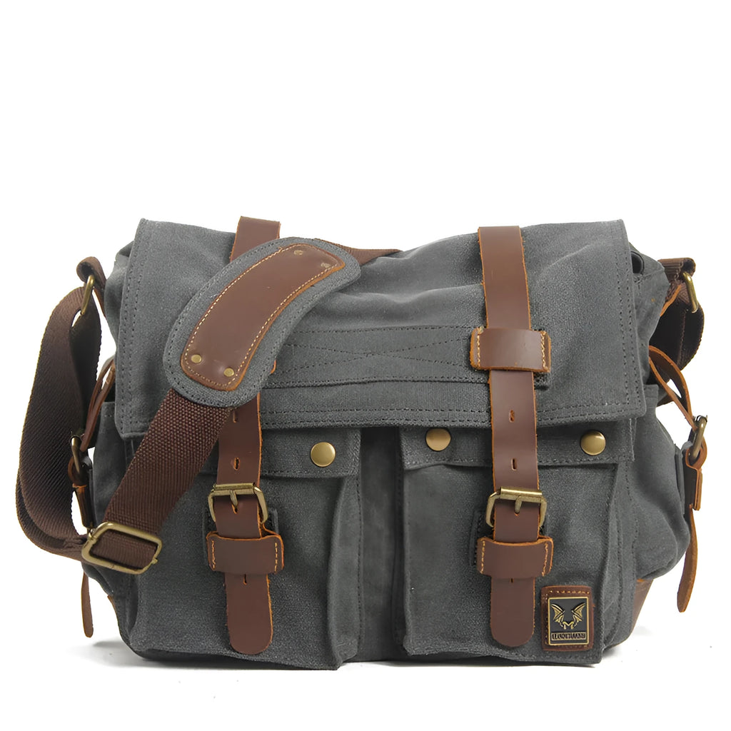 Men's brown canvas crossbody shoulder bag with cowhide trim and flap closure.