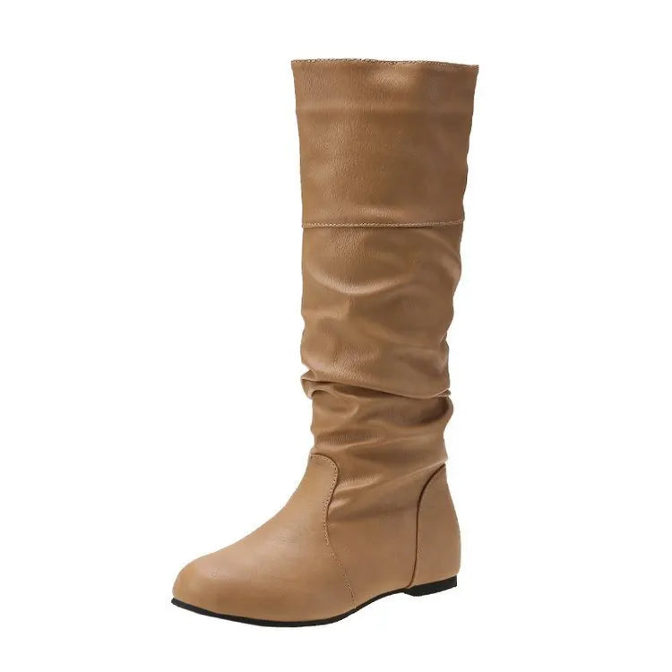 Women's black slip-on flat ankle boots with round toe and high cylinder shaft on a neutral background.