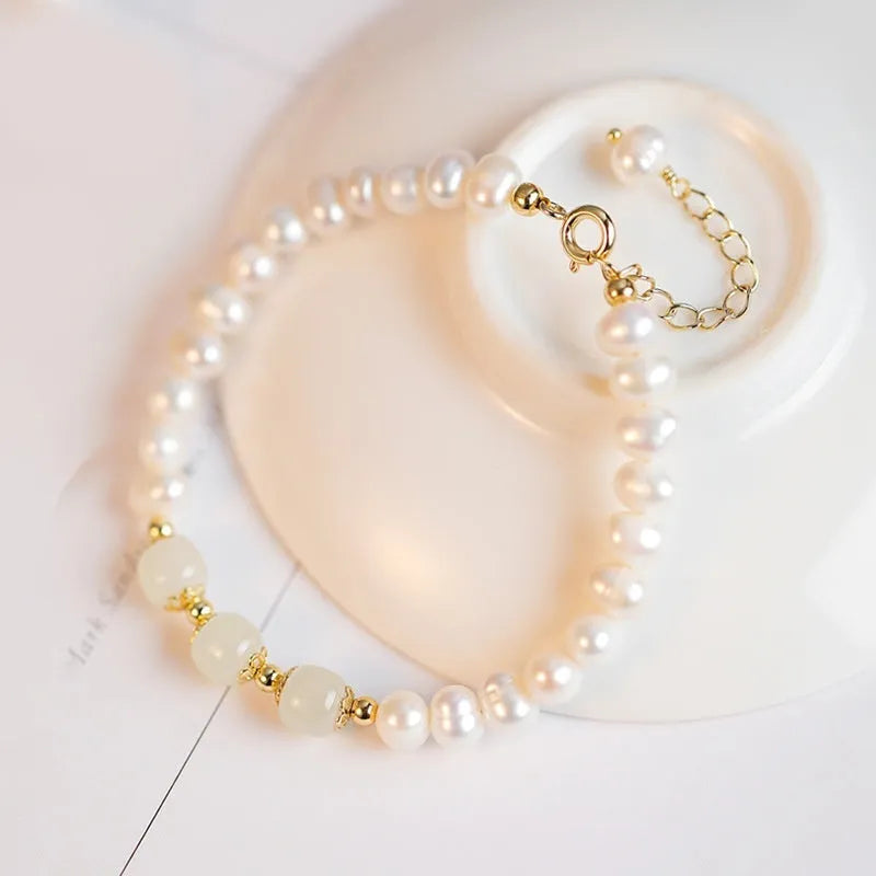 Close-up of a diamond-shaped freshwater pearl bracelet in an electroplated Hetian jade colour on a wrist.