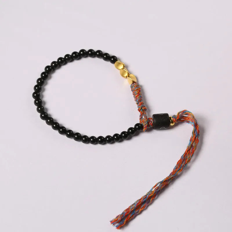 Hand-woven obsidian-coloured strap bracelet showing textured surface and slim 4mm width