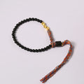 Hand-woven obsidian-coloured strap bracelet showing textured surface and slim 4mm width