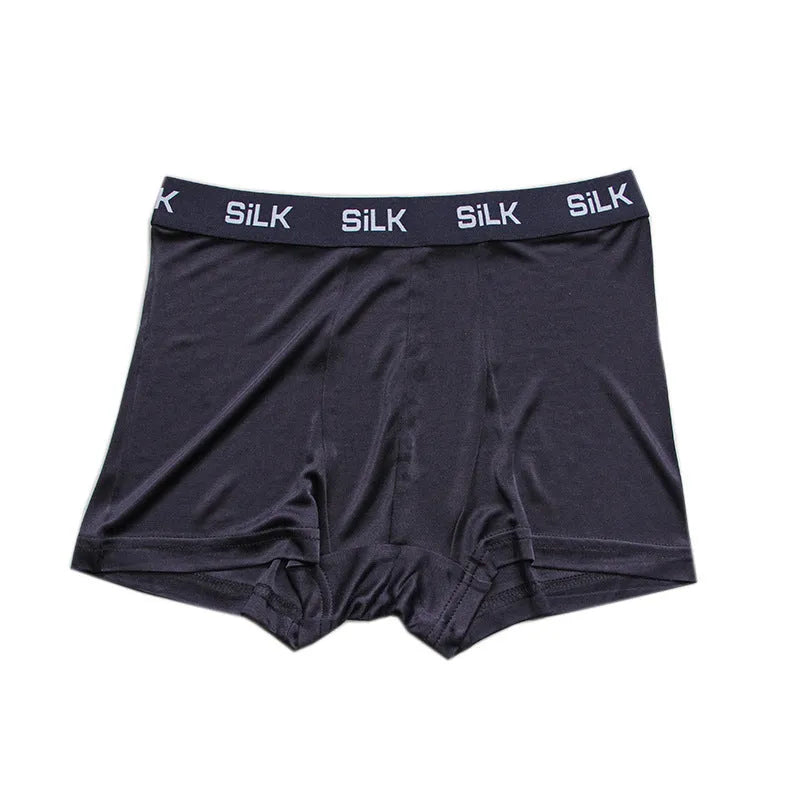 Men's loose fit silk shorts in navy blue, shown in a casual setting