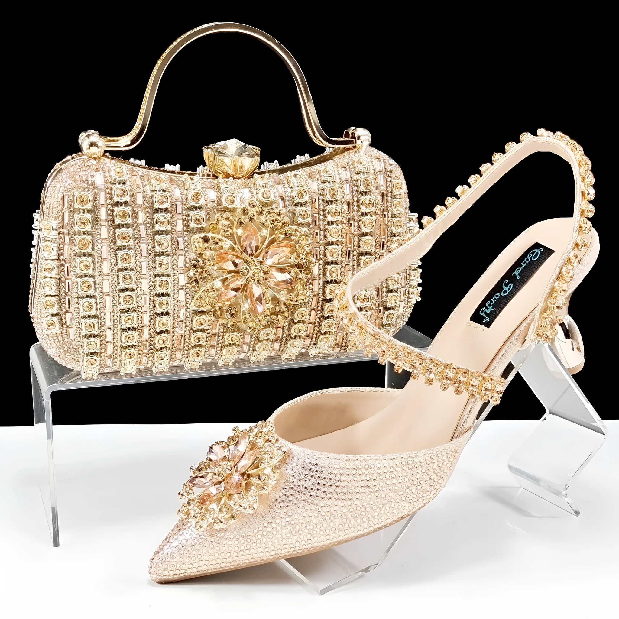 Women's black high heel and matching clutch bag set with rhinestone floral decoration and pointed toe.