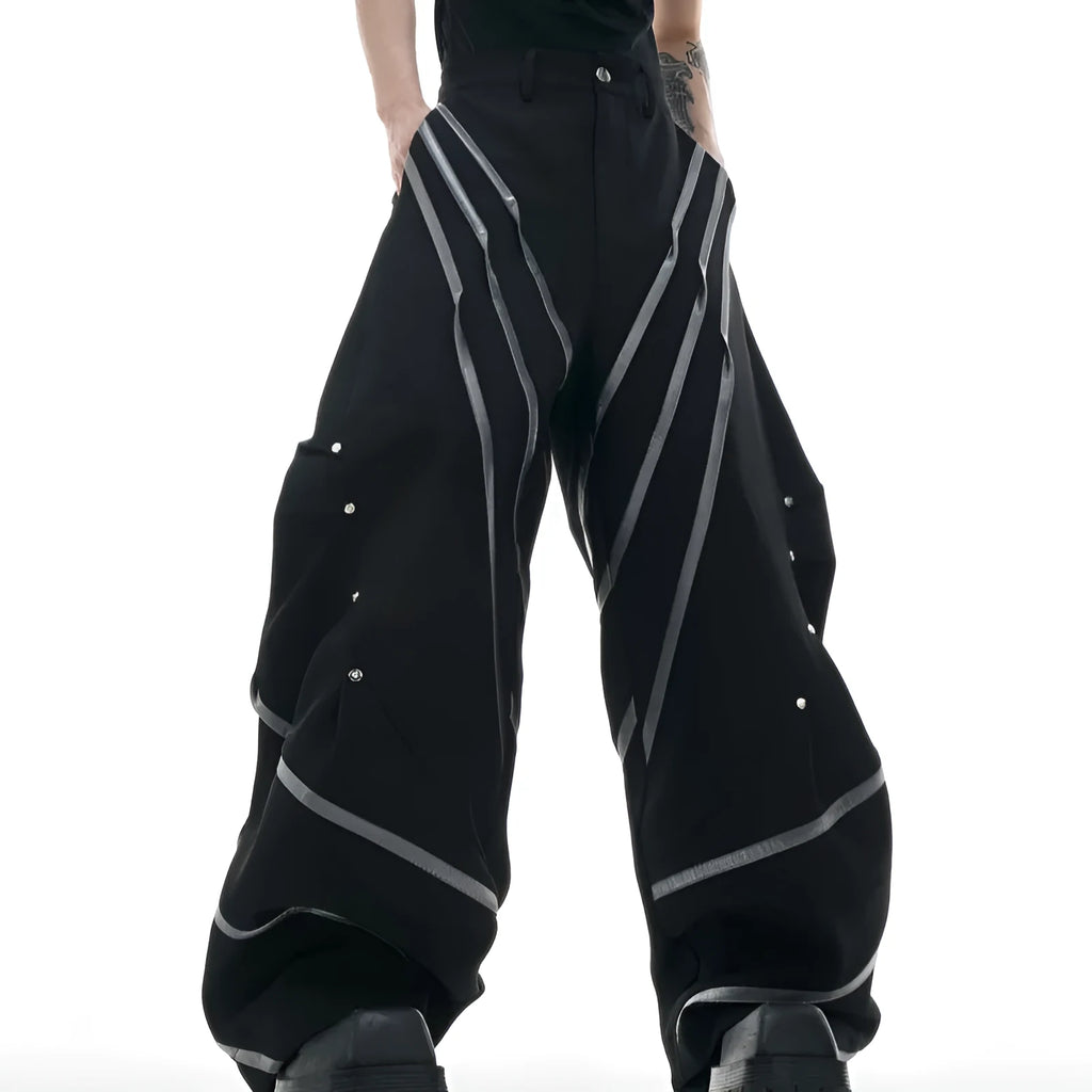 Men's polyester trousers with metal rivet accents and pleated detailing on three-dimensional cutting construction