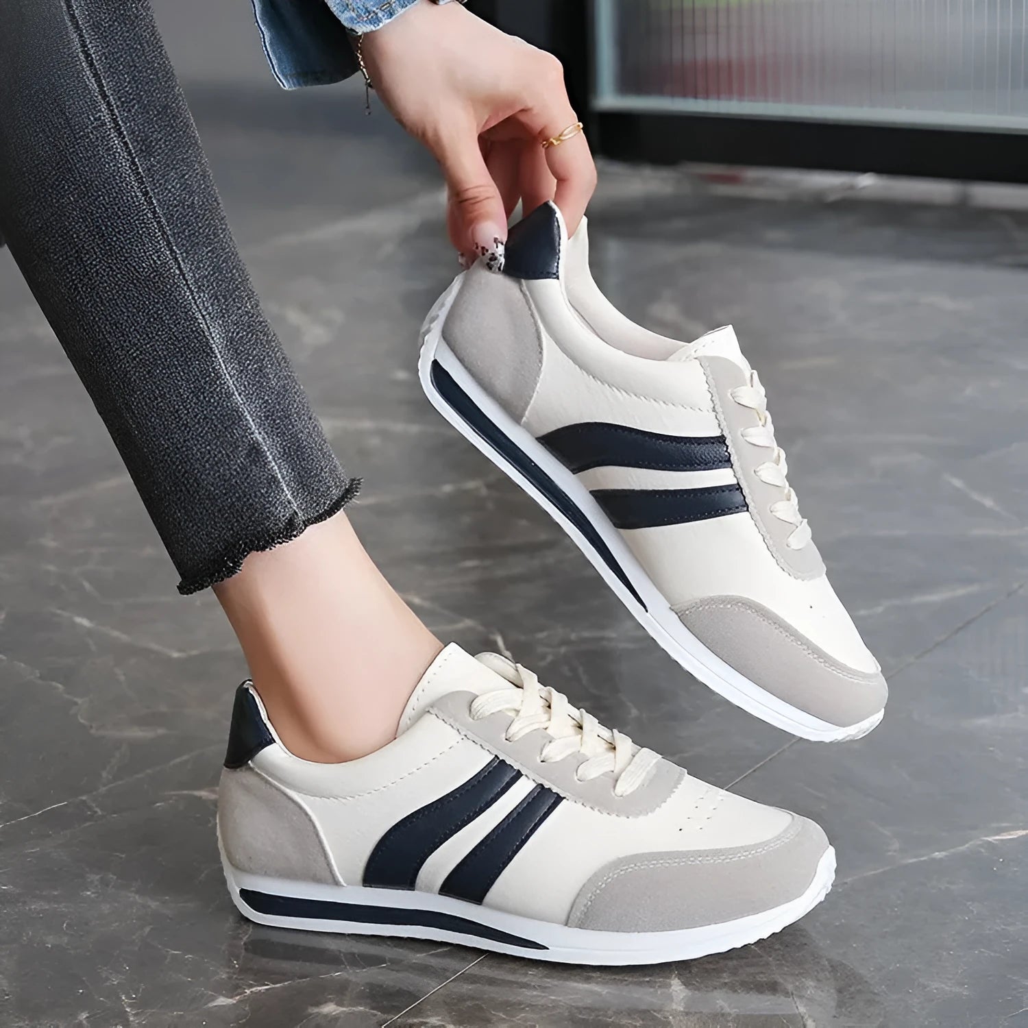 Red and blue low-top lace-up sneakers with rubber sole and mesh upper on white background