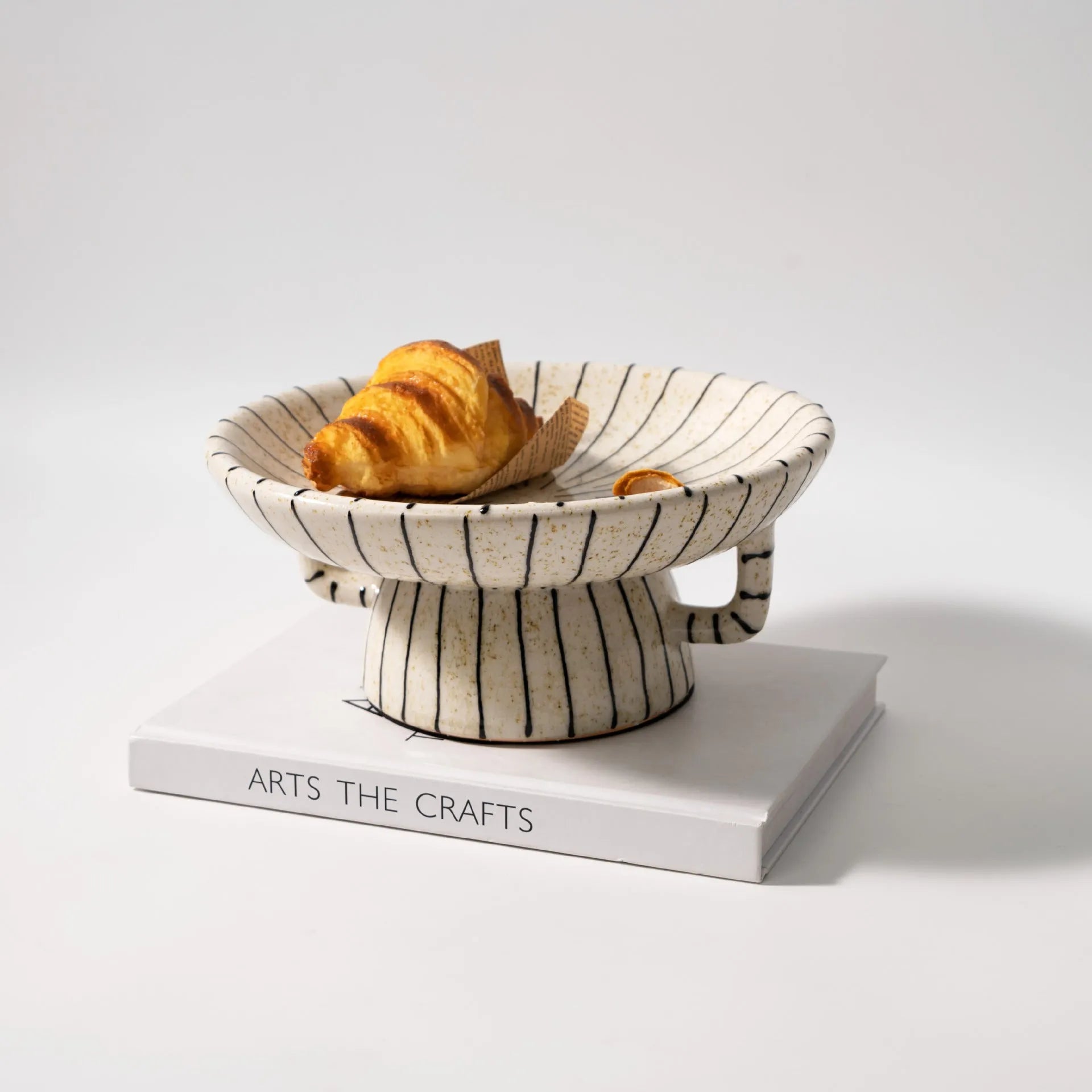 Black and white striped plastic resin dessert plate on a table.