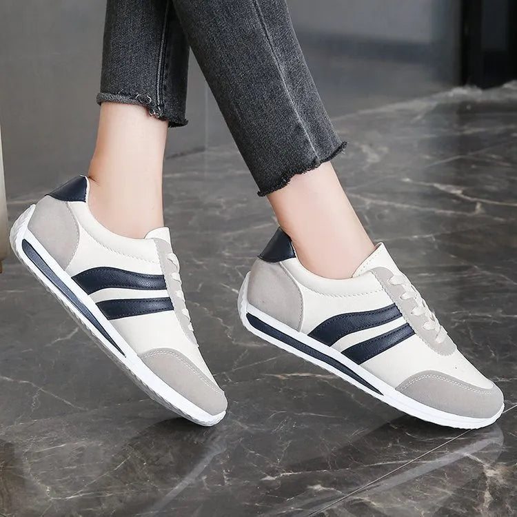 Red and blue low-top lace-up sneakers with rubber sole and mesh upper on white background