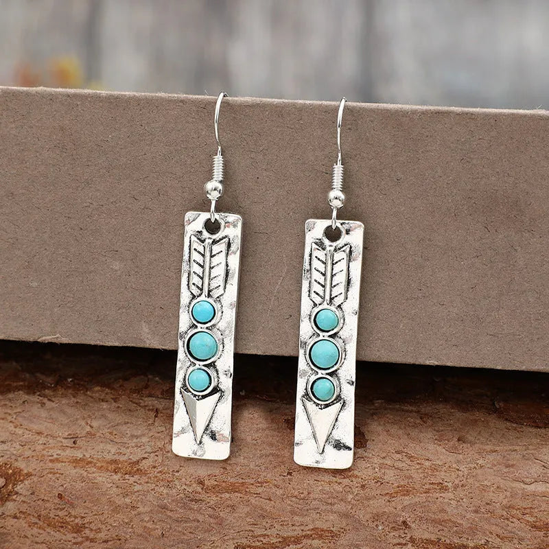 Long geometric silver earrings with turquoise stone accents and retro design