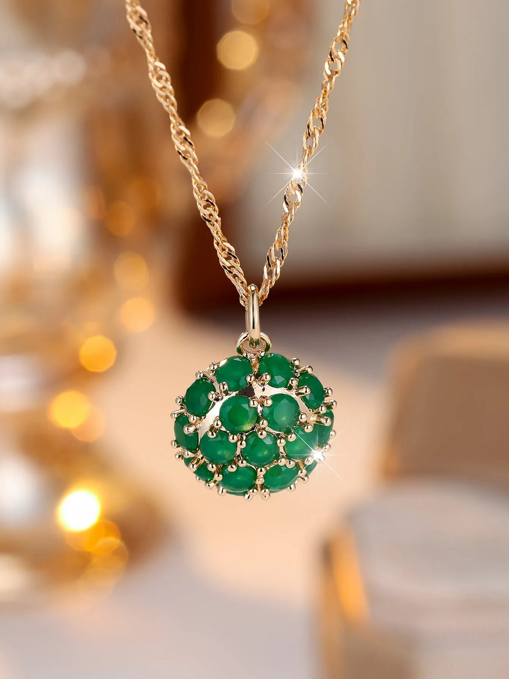 Geometric pendant necklace with emerald and diamond detailing on adjustable champagne gold chain