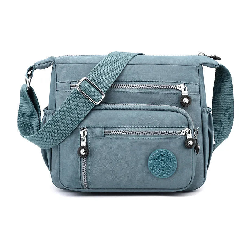 Soft nylon messenger bag in square vertical shape with an adjustable shoulder strap.