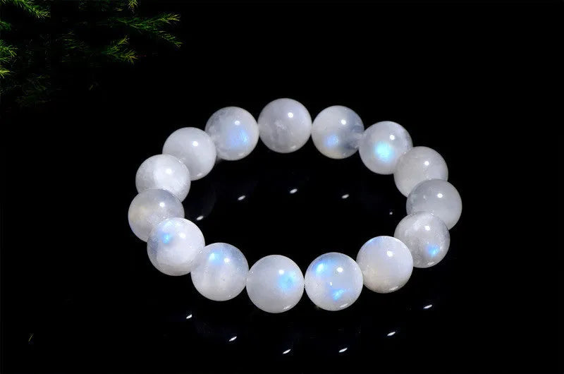 Polished natural blue moonlight moonstone round bead bracelet on white background, showing geometric facets.