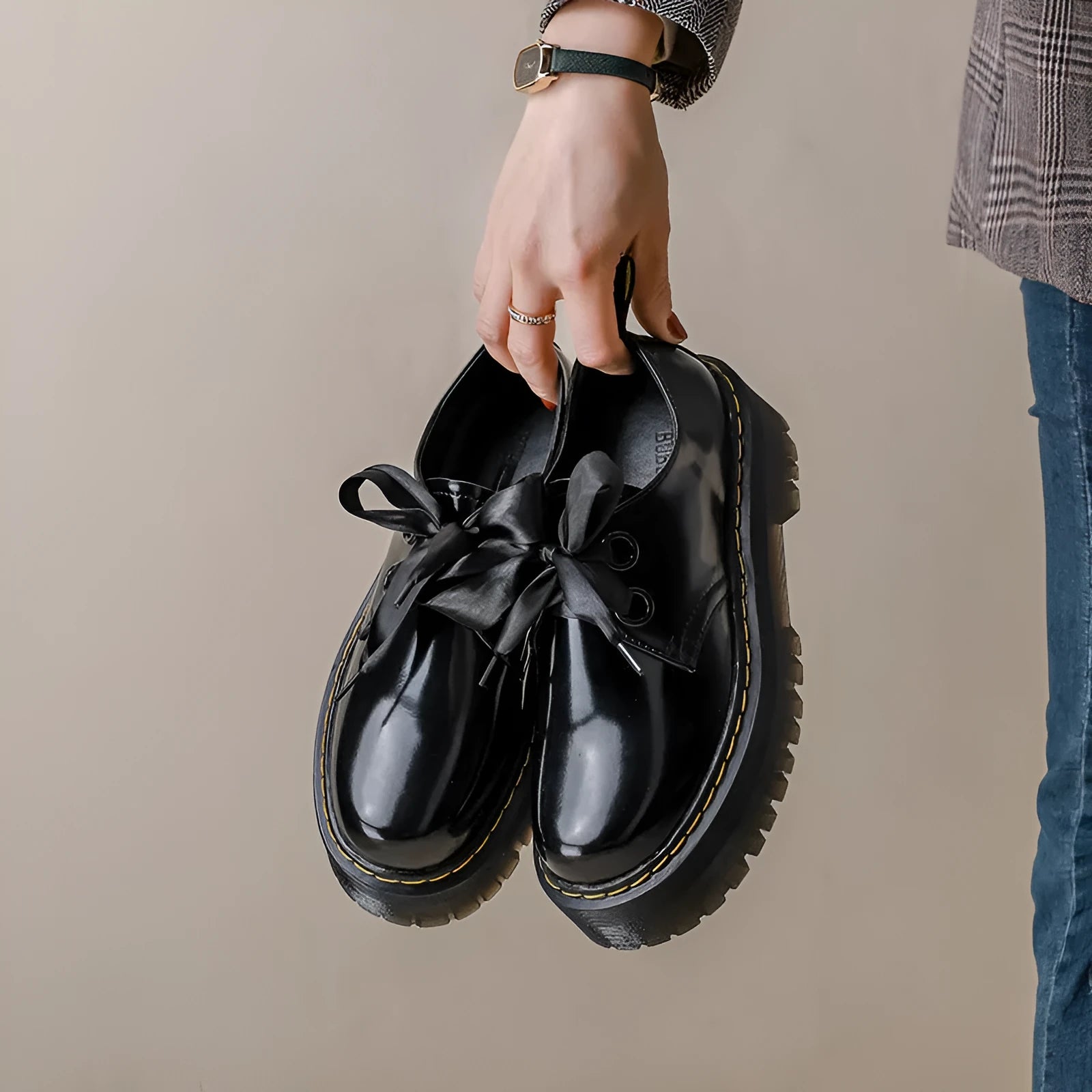 Women's white and black leather shoes with thick soles, ribbon and cross-strap design, and laced closure.