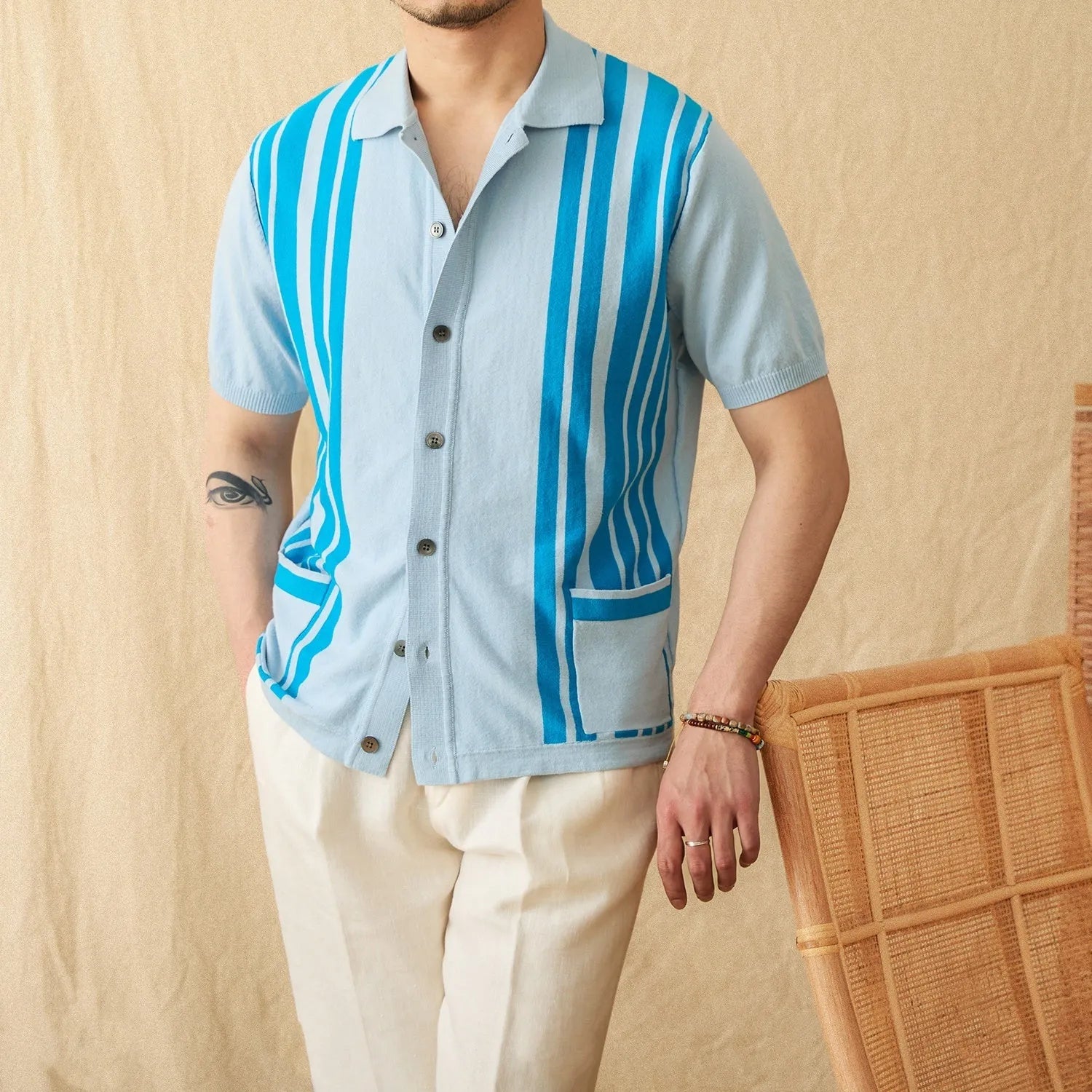 A man wearing a royal blue short-sleeved knitted polo shirt with a lapel collar.