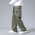 Boy wearing straight leg cargo pants with drawstring waist and large side pockets in army green.