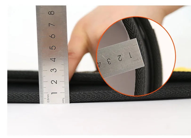 Black nylon fitness weightlifting belt on a gym floor, showing adjustable buckle and supportive width.