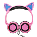 Colourful cat ear headphones with illuminated RGB LED lights in the ears and ear cushions on a black background.