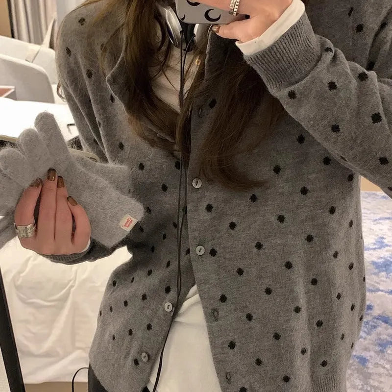 Women's grey loose-fit knitted cardigan with long sleeves on a hanger.