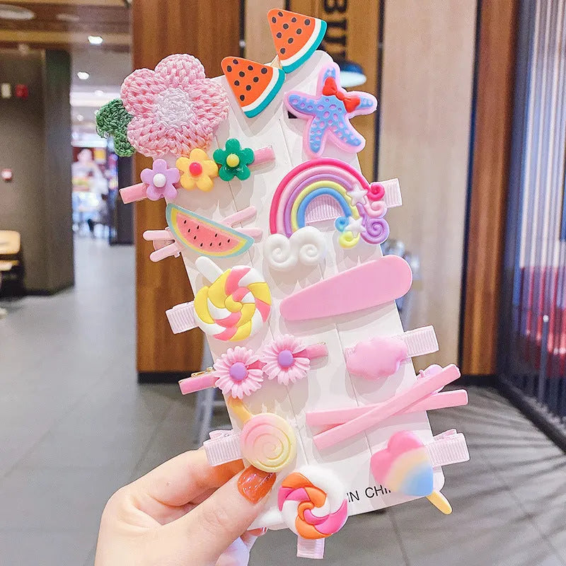 14-piece set of colourful toddler hair clips with candy, fruit, rainbow, and butterfly designs on a white background.