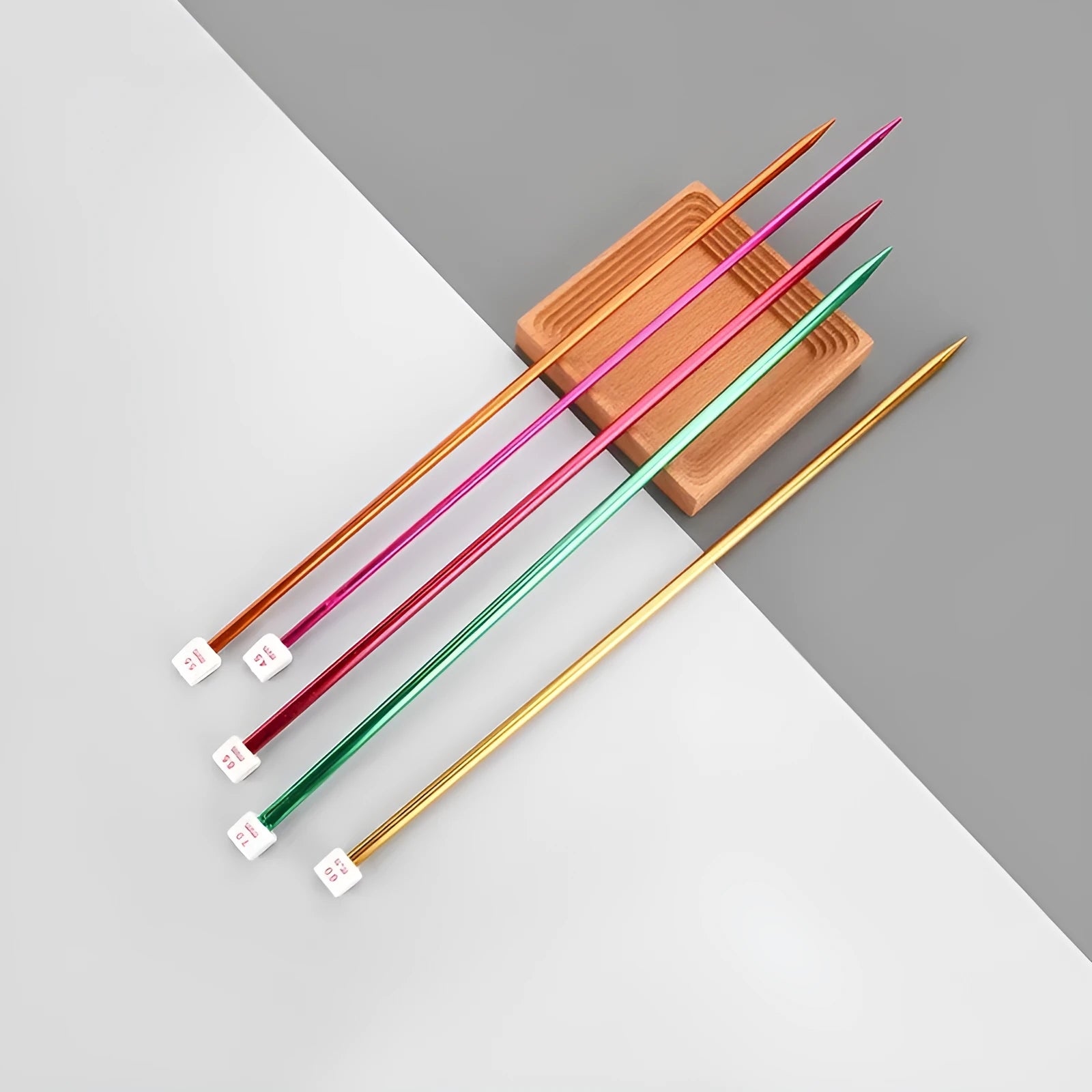 Complete set of aluminium crochet hooks in 14 sizes with protective caps laid out on a table.
