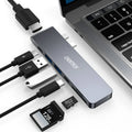 Silver aluminium 7-in-1 USB-C hub adapter with SD card slot, HDMI, USB 3.0, and charging ports.