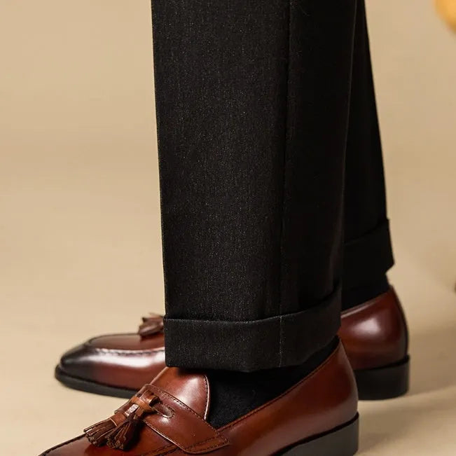 Men's black polished leather tassel loafers with a pigskin lining and rubber sole