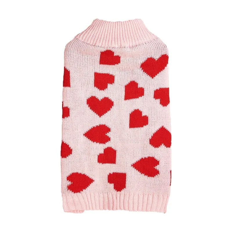 Red love heart design dog sweater on a small dog, showing pink bow detail.