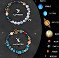 Two natural stone beaded bracelets with zodiac symbol charms on a jewellery display