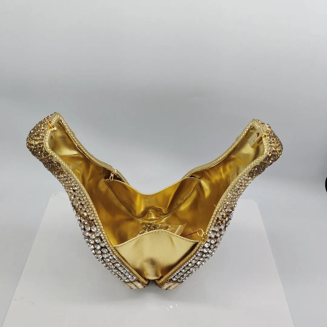 Gold hard-shell clutch bag shaped like a champagne bottle with crystal accents on a black background.
