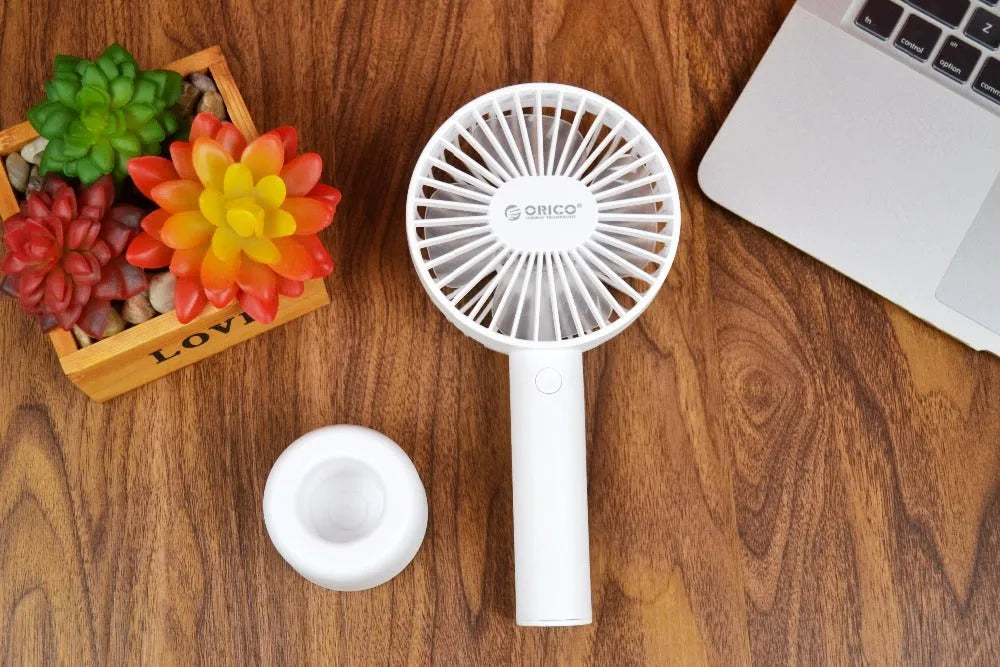 White ORICO FH1 portable USB rechargeable fan with fine line detailing, shown in handheld and desktop positions.