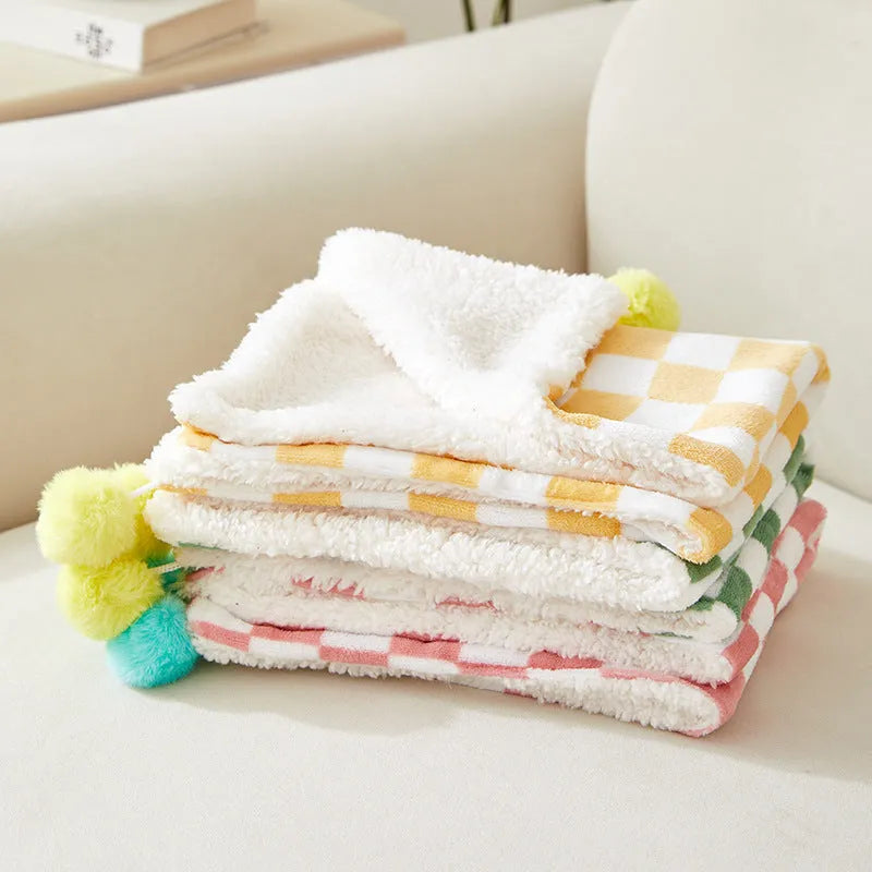 Plaid pattern pet blanket with fur ball decoration in green, pink, or yellow colours on soft fleece material