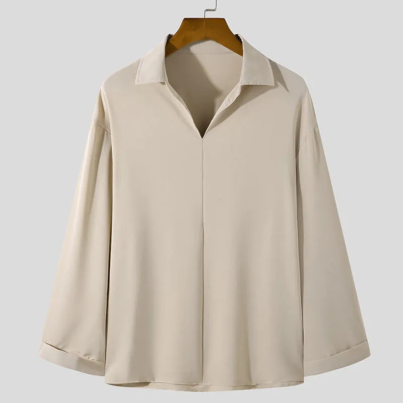 Man wearing a loose lapel, long sleeve casual shirt in a solid colour.