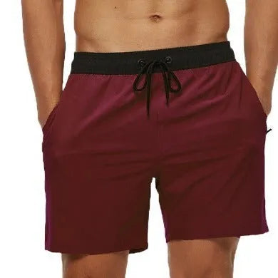 Men's blue athletic shorts with stitching waist detail and zipper pockets for running and fitness