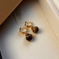 Geometric round tigereye stone earrings for women with gold plating in black and brown.